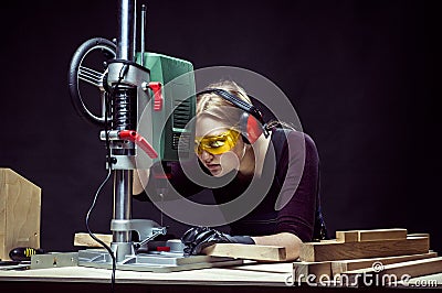 Female carpenter and drilling machine. Stock Photo