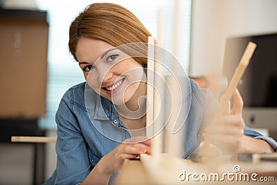 female carpenter gluing wooden planks Stock Photo