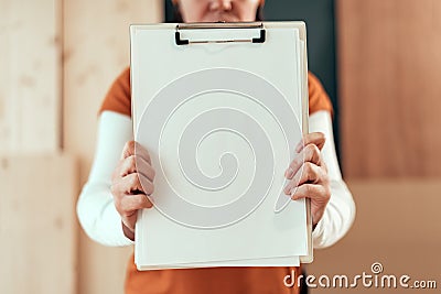 Female carpenter holding clipboard note pad paper mock up Stock Photo