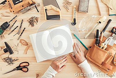 Female carpenter reading DIY project instruction manual Stock Photo