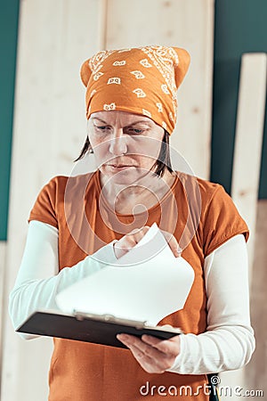 Female carpenter reading DIY project notes Stock Photo