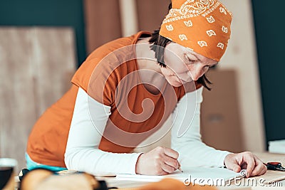 Female carpenter sketching project draft notes in woodwork workshop Stock Photo