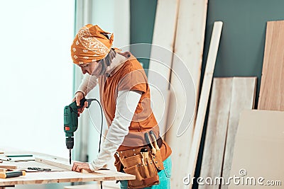 Female carpenter using electric drill Stock Photo