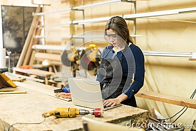 Female carpenter using a laptop Stock Photo