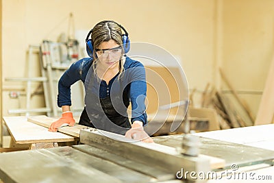 Female carpenter using a table saw Stock Photo