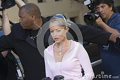 Female Celebrity With Bodyguard And Paparazzi Stock Photo