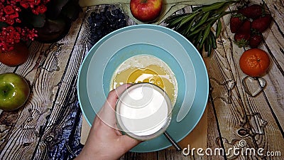 Female chef pouring milk in a bowl, pancake preparation, top view Stock Photo