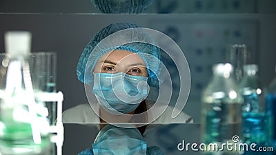 Female chemical in protective uniform looking at camera, working in laboratory Stock Photo