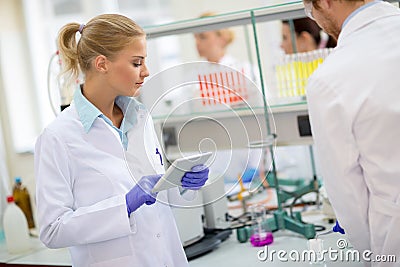 Female chemical technician noting data in laboratory Stock Photo