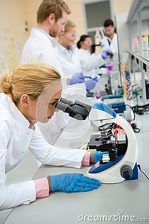 Female chemical works with microscope Stock Photo