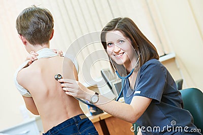 Female children`s pediatrician doctor during little boy examination Stock Photo