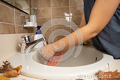 Female cleaning her hands in circular bathroom sink Stock Photo