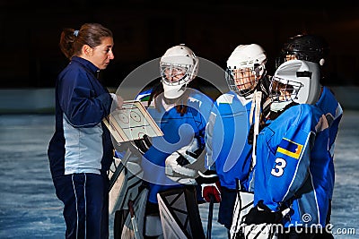 Female coach explaining game plan to hockey team Stock Photo
