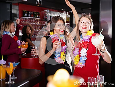 Female colleagues on company party in Hawaiian style in bar Stock Photo