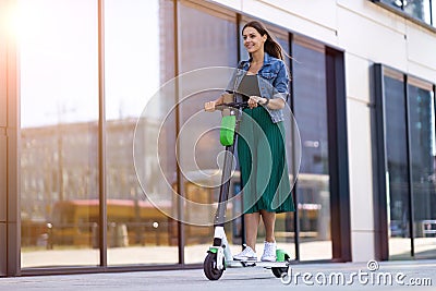 Female commuter riding electric push scooter Stock Photo