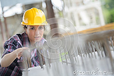 Female construction worker installing binding steel wires Stock Photo