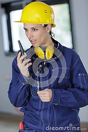 female construction worker relaying directions on walkie talkie Stock Photo