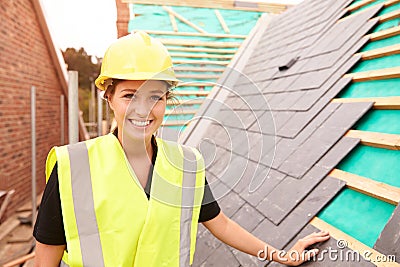 Female Construction Worker On Site Laying Slate Tiles Stock Photo