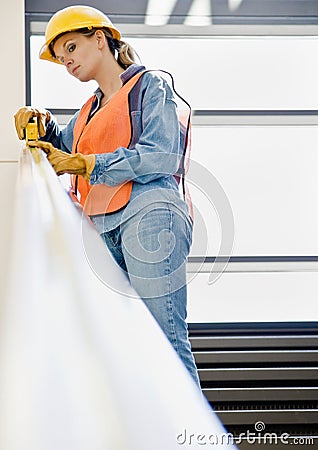 Female construction worker taking measurement Stock Photo