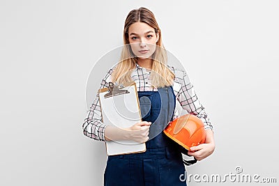 female constructor builder holding orange helmet and paper clipboard posing at camera Stock Photo