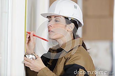 Female constructor showing measuring wall Stock Photo