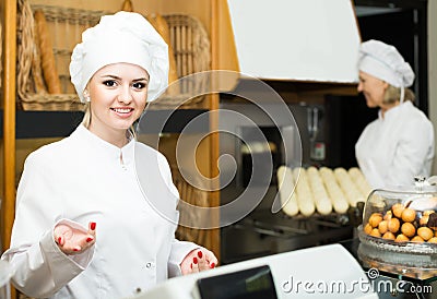 Female cooks with fresh and tasty bread in bakery Stock Photo