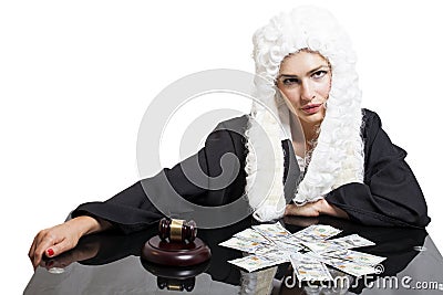 Female corrupt judge with gavel and money at table Stock Photo