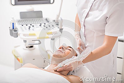 Female cosmetologist undergoing laser therapy Stock Photo