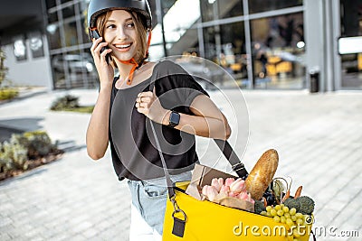 Female courier delivering fresh food with a backpack Stock Photo