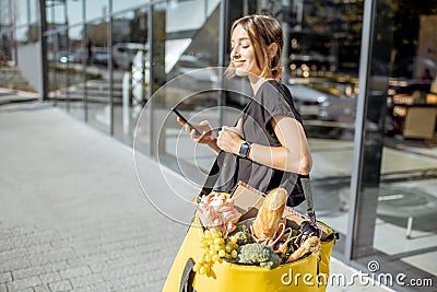 Female courier delivering fresh food with a backpack Stock Photo