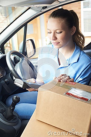 Female Courier In Van Delivering Package To House Stock Photo