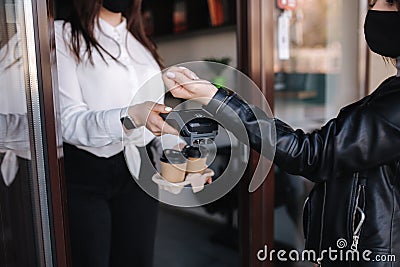 Female customer making wireless or contactless payment using smartwatch. Cashier accepting payment over nfc technology Editorial Stock Photo