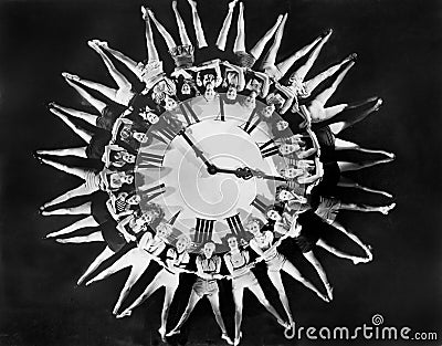 Female dancers circling huge clock Stock Photo