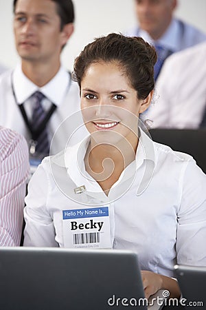 Female Delegate Listening To Presentation At Conference Making Notes On Laptop Stock Photo