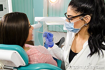 Female dentist checking teeth to young woman Stock Photo