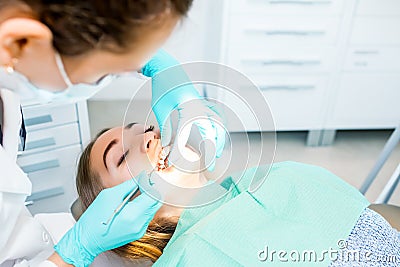 Female dentist checking up patient teeth with braces at dental clinic office. Medicine, dentistry concept. Dental Stock Photo