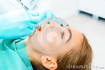 Female dentist checking up patient teeth with braces at dental clinic office. Medicine, dentistry concept. Dental Stock Photo