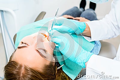 Female dentist checking up patient teeth with braces at dental clinic office. Medicine, dentistry concept. Dental Stock Photo