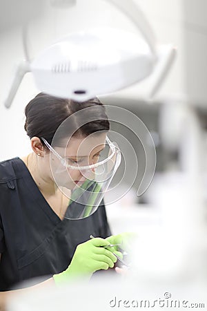 A female dentist examines the oral cavity of a patient Stock Photo