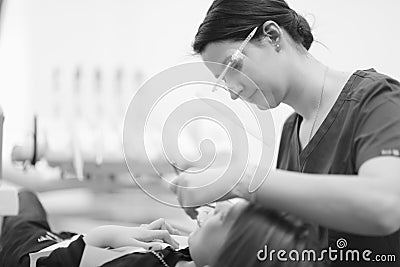 A female dentist examines the oral cavity of a patient Stock Photo