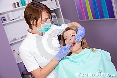 Female dentist in mask and young female patient Stock Photo