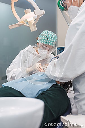 Female dentist with a patient in her office. Patient with open mouth and woman dentist working. dental health concept Stock Photo