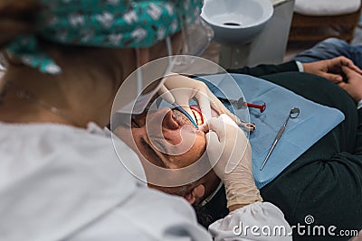 Female dentist with a patient in her office. Patient with open mouth and woman dentist working. dental health concept Stock Photo