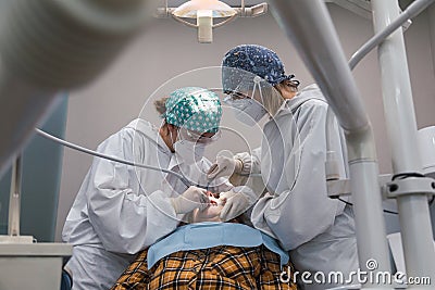 Female dentist with a patient in her office. Patient with open mouth and woman dentist working. dental health concept Stock Photo