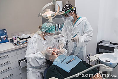 Female dentist with a patient in her office. Patient with open mouth and woman dentist working. dental health concept Stock Photo