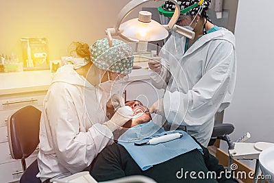 Female dentist with a patient in her office. Patient with open mouth and woman dentist working. dental health concept Stock Photo