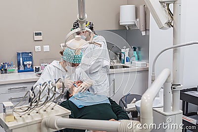 Female dentist with a patient in her office. Patient with open mouth and woman dentist working. dental health concept Stock Photo