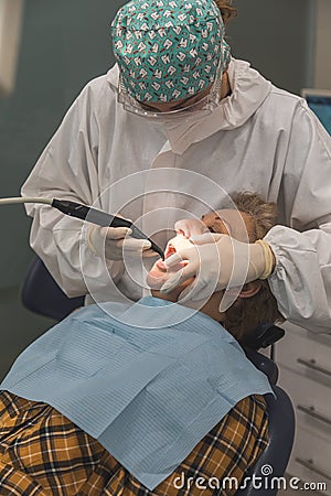 Female dentist with a patient in her office. Patient with open mouth and woman dentist working. dental health concept Stock Photo