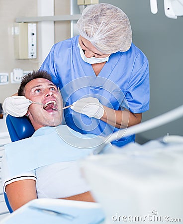 Female dentist treating male patient Stock Photo
