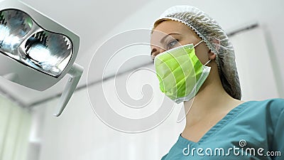 Female dentist wearing mask and cap before operation, professional services Stock Photo